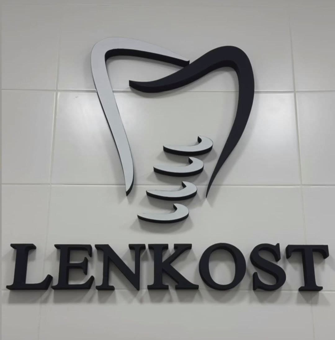 объемные буквы LENKOST и логотип в форме зуба на стене