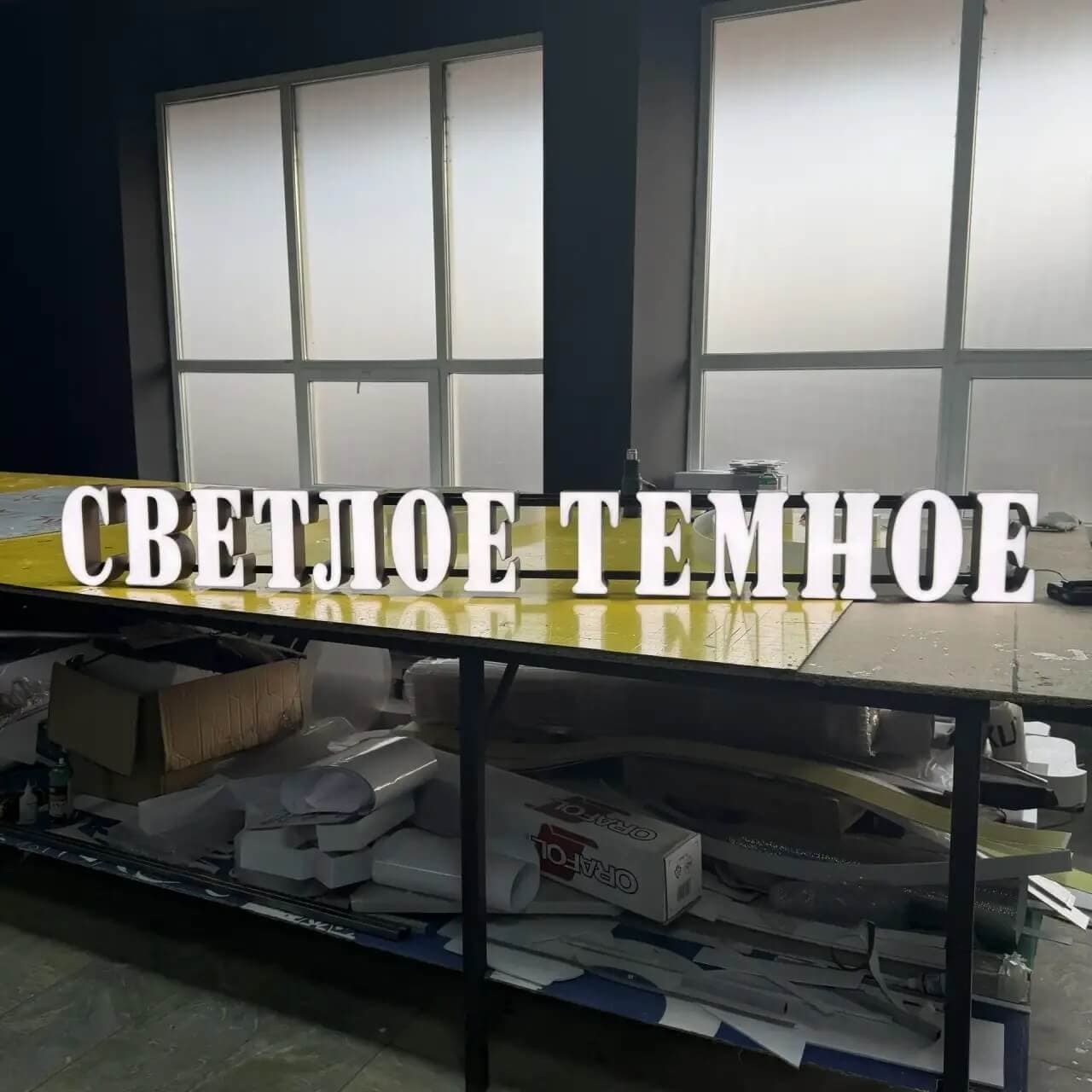 Объемные световые буквы СВЕТЛОЕ ТЕМНОЕ на металлической раме в процессе сборки